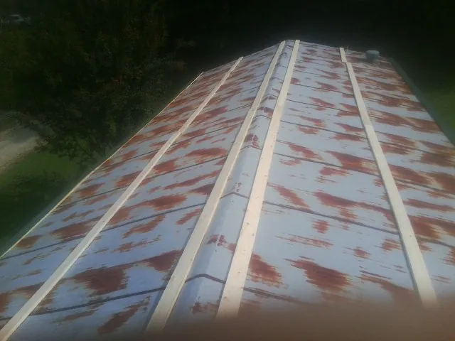 Rusted metal roof panels with new wood purlins before replacement — Storm Damage Roof Repair in Hedgesville by Roofing Brothers