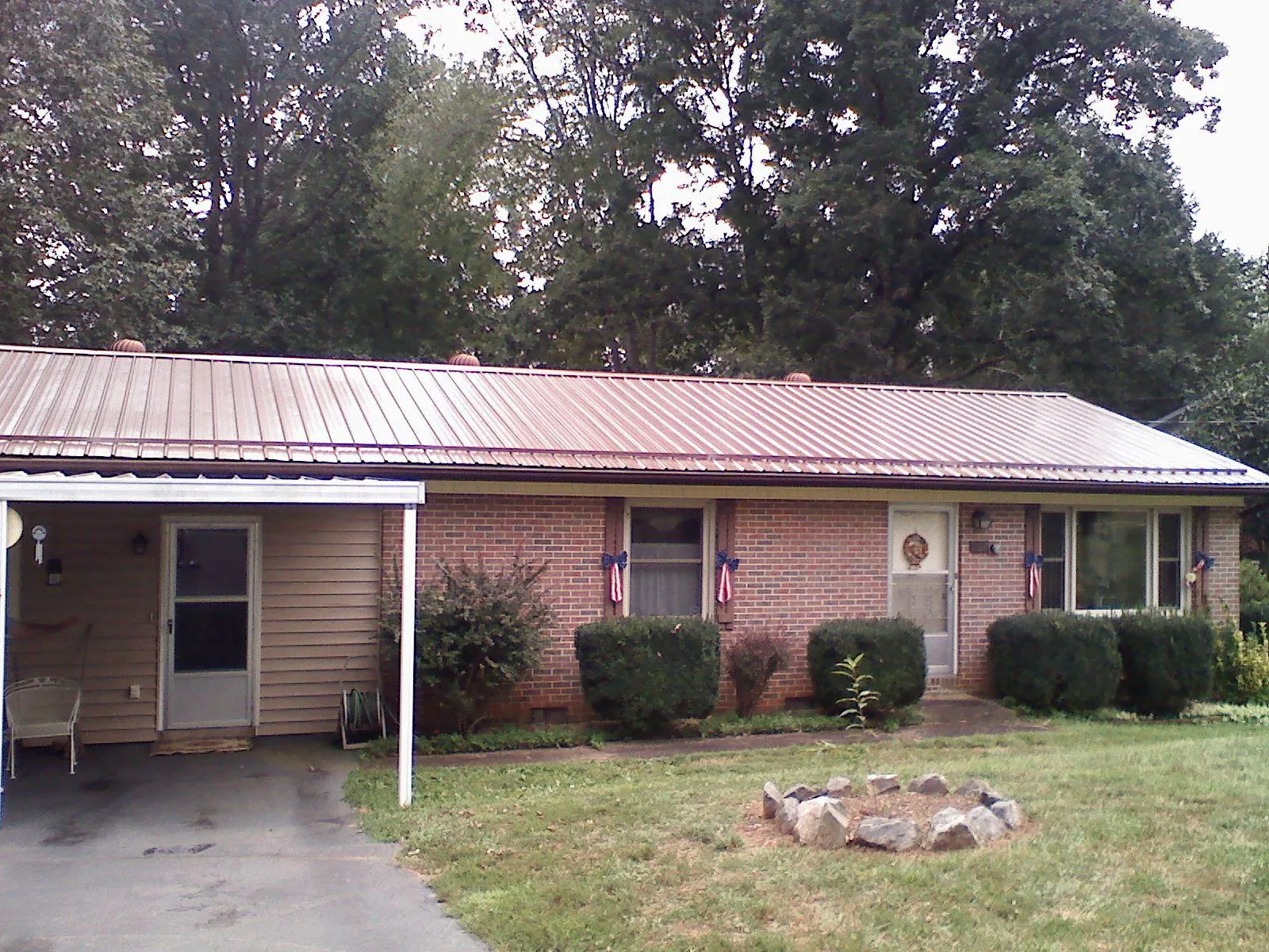 Bronze metal roof and carport on a brick ranch home — Roof Repair work by our crew in Hedgesville